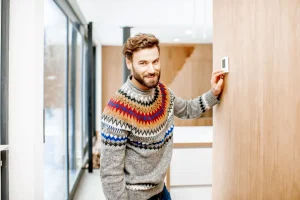 man-adjusting-temperature-with-thermostat-at-home-2025-03-14-03-37-38-utc